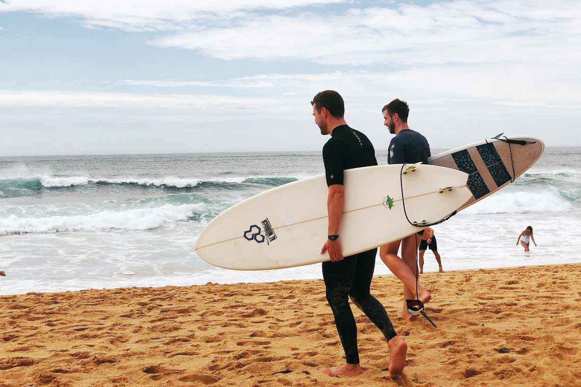 Surfistas en la playa Côte des Basques de Biarritz al atardecer